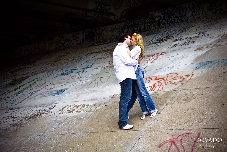 Couple kisses on graffiti covered overpass