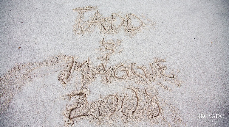 bride and grooms names written in sand
