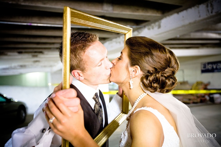 bride and groom kiss through picture frame