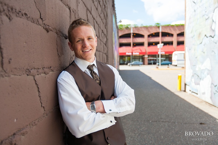 groom posing in a brick alley