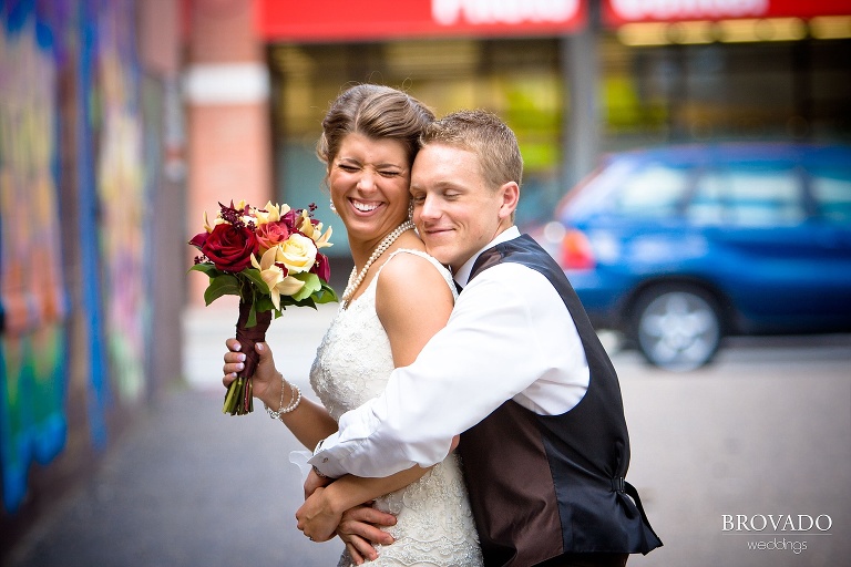 bride laughing as the groom hugs her from behind