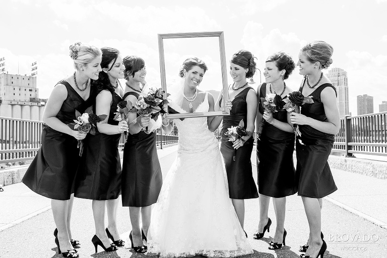bride and bridesmaids pose on stone arch bridge