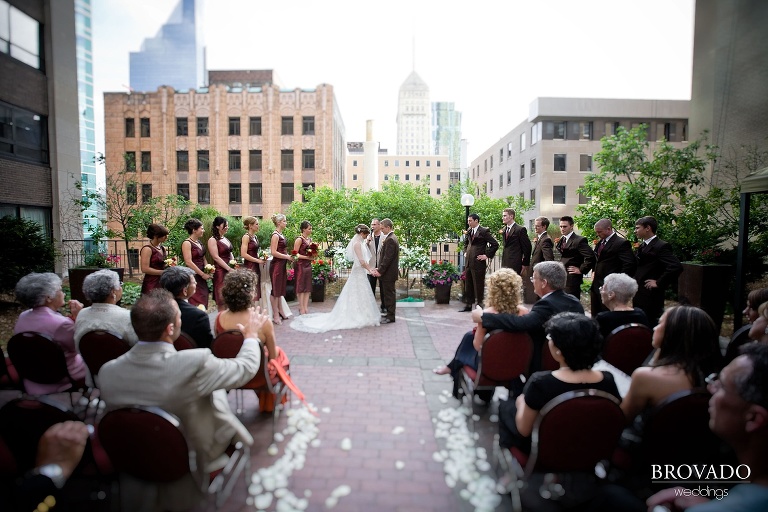 bride and groom standing in front of guests and minneapolis skyline