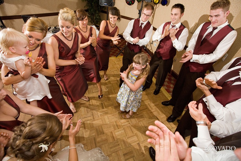 wedding party dancing around a smiling child