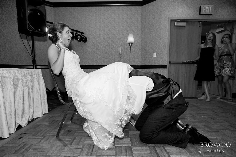 bride screaming while groom pulls off her garter