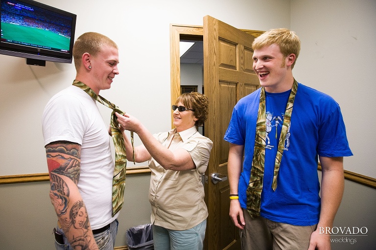 two men get help putting on their green ties