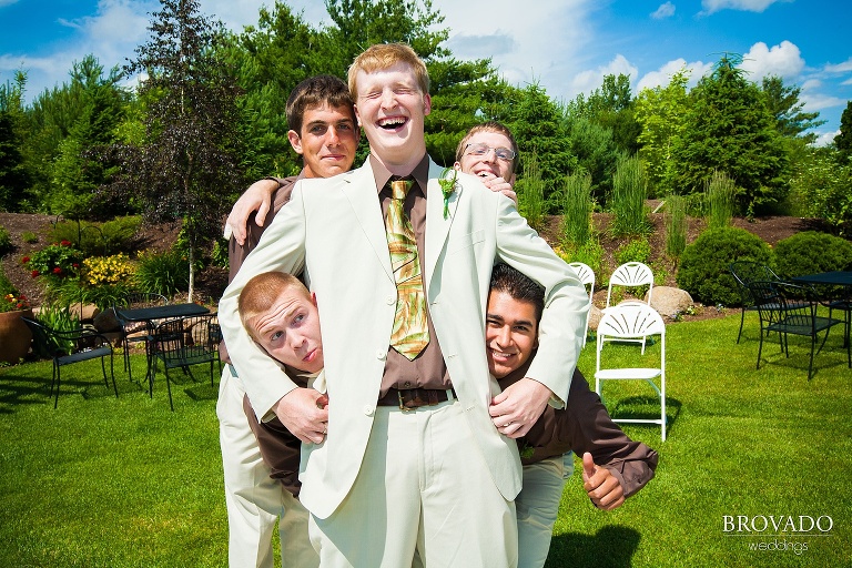 groomsmen surround the groom in an embrace