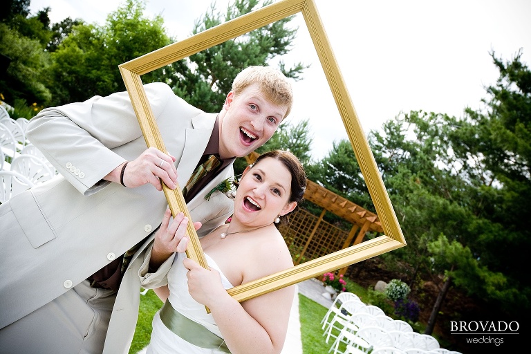bride and groom pose through a picture frame