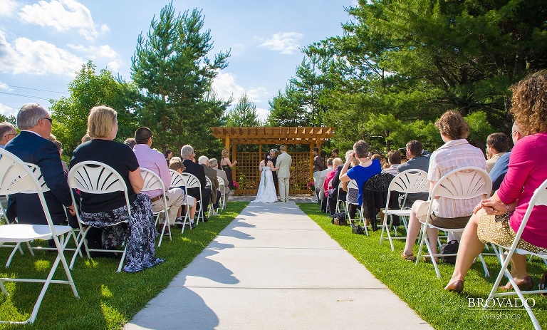 bride and groom stand together under wood awning