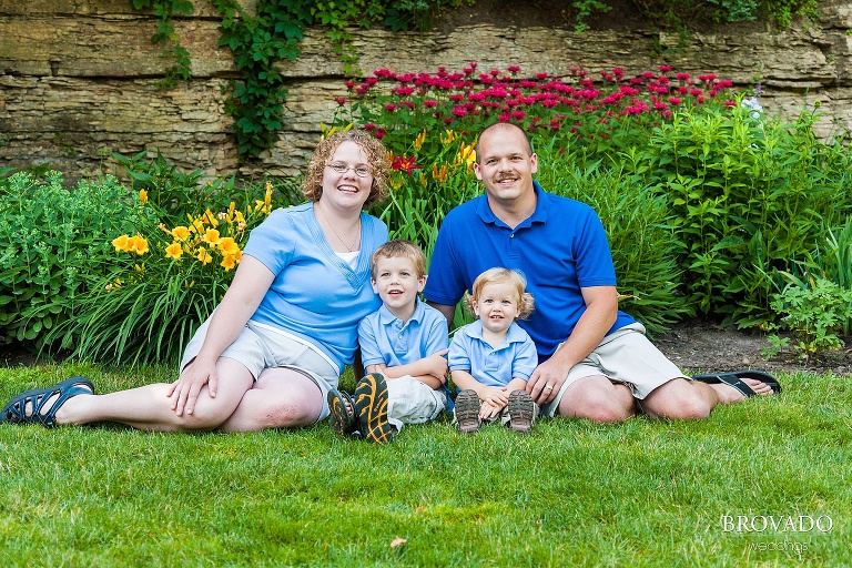 family all in blue sits together on grass