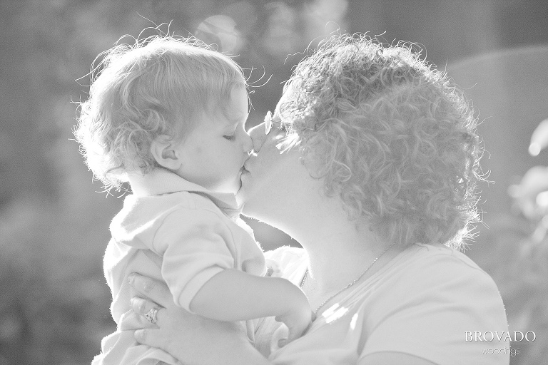 mother kisses her son in the sun