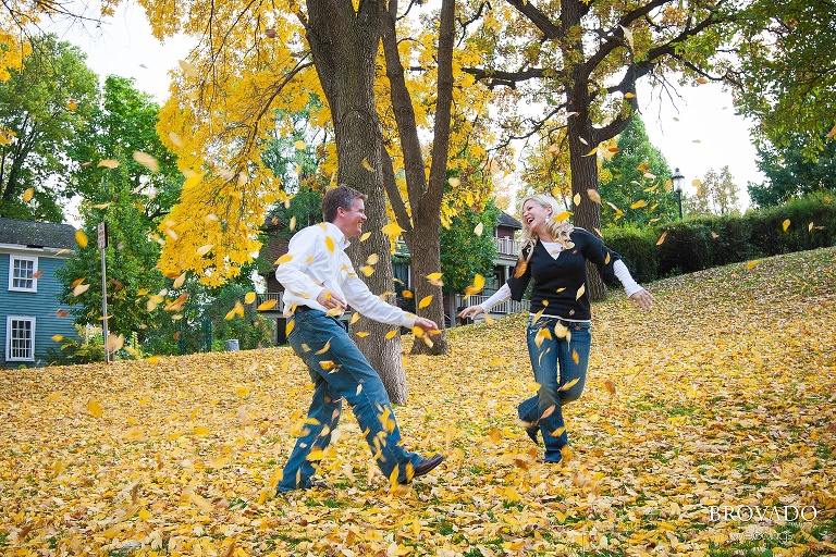 couple plays with fall leaves