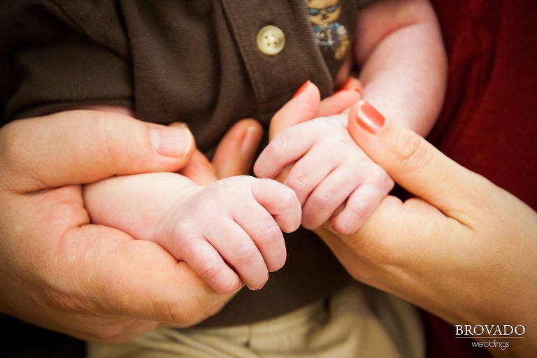 close up of parents holding newborn's hands