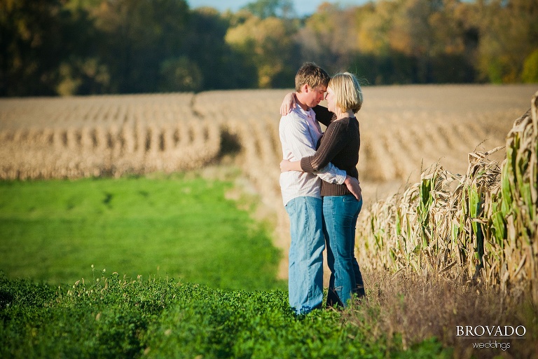 couple embrace next to a corn field