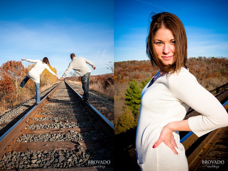 engaged couple holds hands across railroad tracks