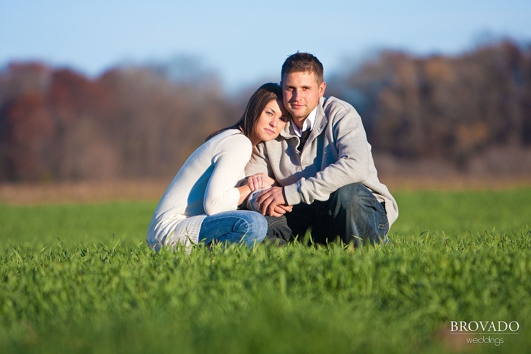 couple embraces in field