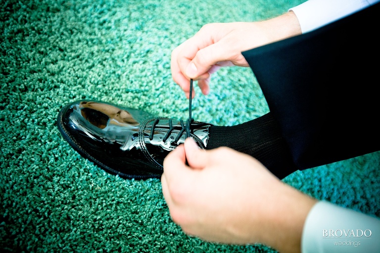 close up of groom tying his shoes