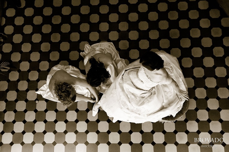 bridesmaids putting on brides shoes from an aerial view