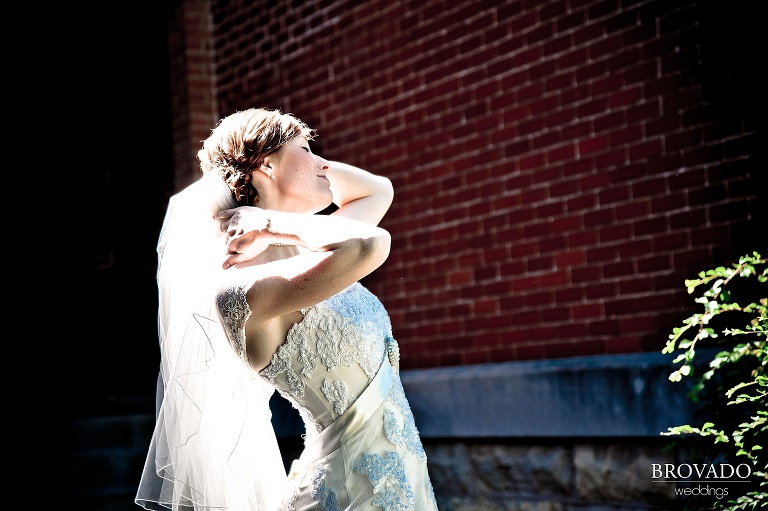 bride adjusting her veil in the sunshine
