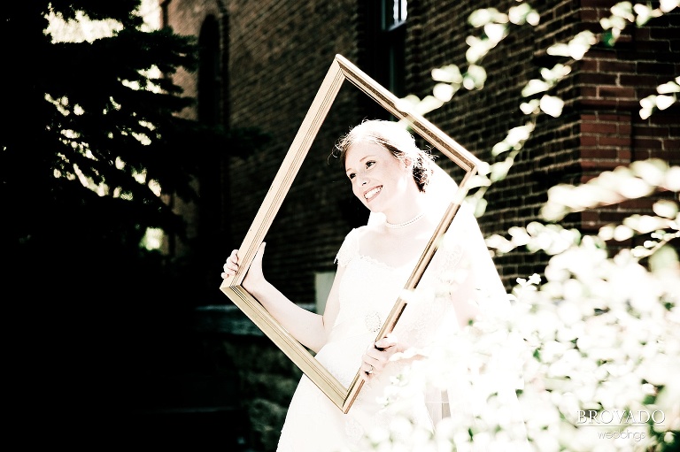 bride smiling sweetly through a picture frame