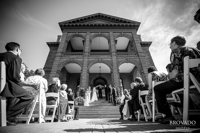 bride and groom standing at an outdoor altar in black and white