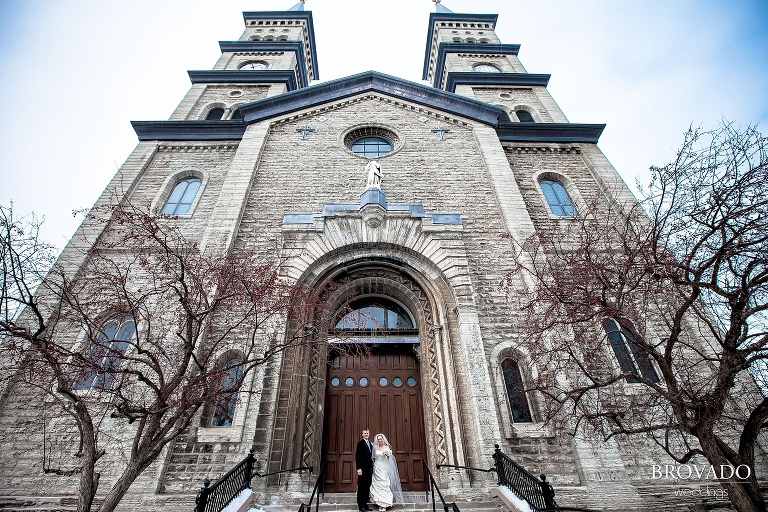 bride and groom in front of assumption catholic church
