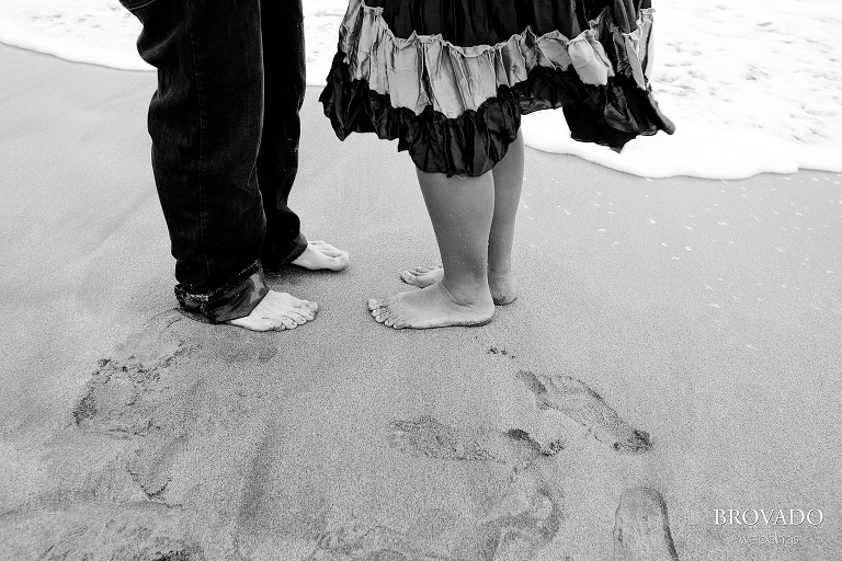 close up of fiances feet in sand