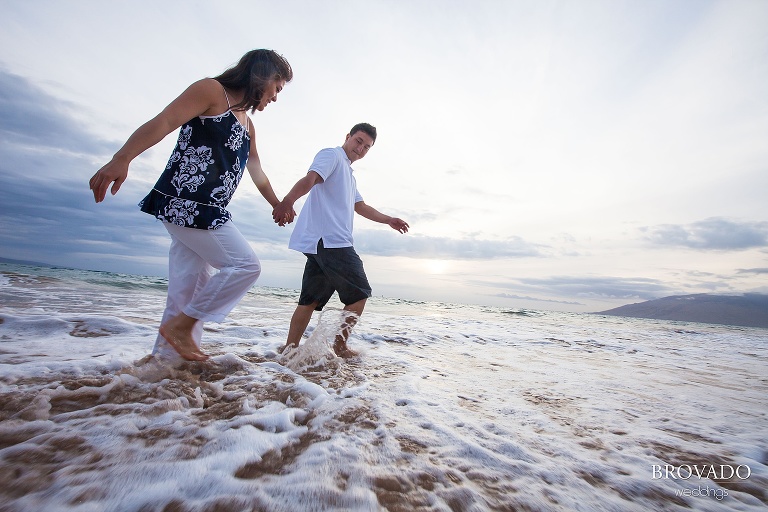 couple holding hands in the ocean