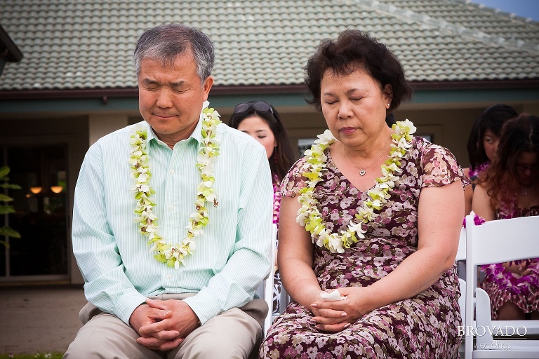 parents of the bride close their eyes during wedding ceremony