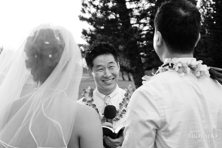 officiant smiling at newlyweds