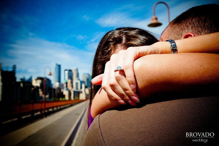 closeup of engagement ring on stone arch bridge