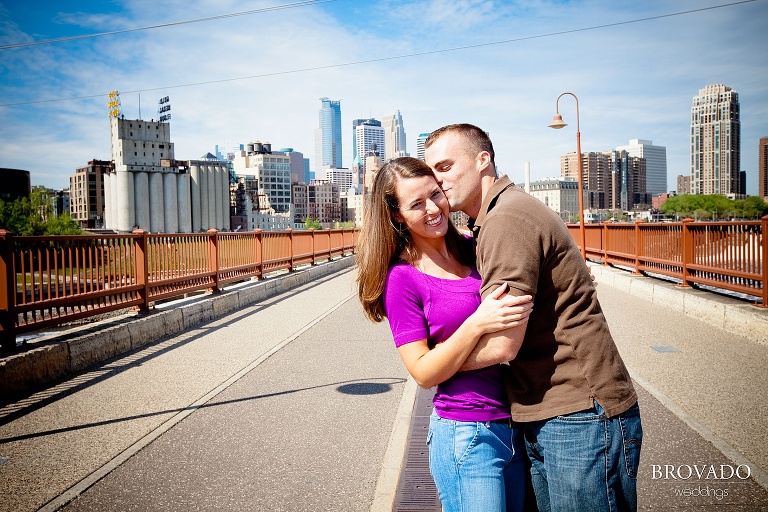 fiances kiss in front of minneapolis skyline