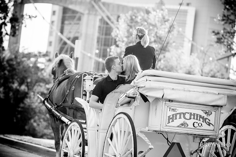couple kissing in horse drawn carriage on the stone arch bridge