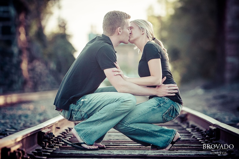 couple kissing on railroad tracks