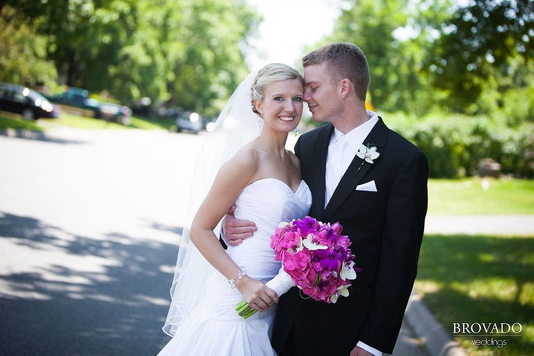 high contrast photograph of bride looking at the camera while the groom embraces her