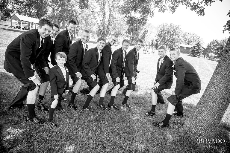 groomsmen show off their tall socks in a goofy black and white photograph