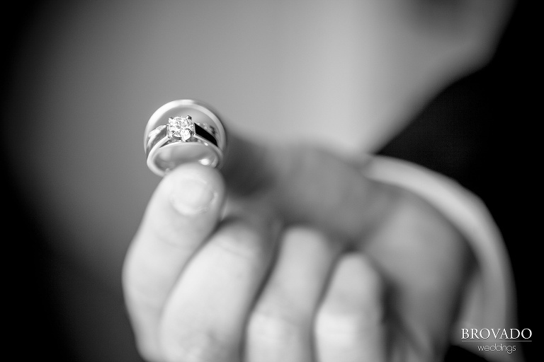 close up photograph of groom holding wedding rings