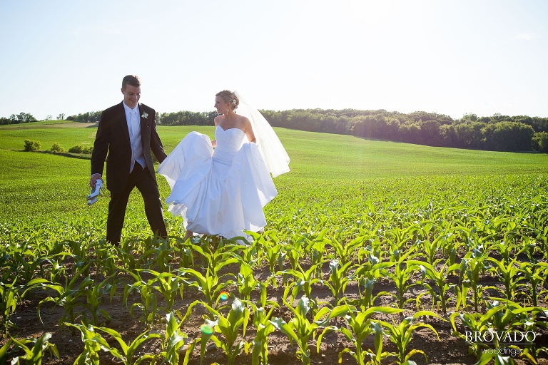 bright photograph of bride and groom smiling in a field
