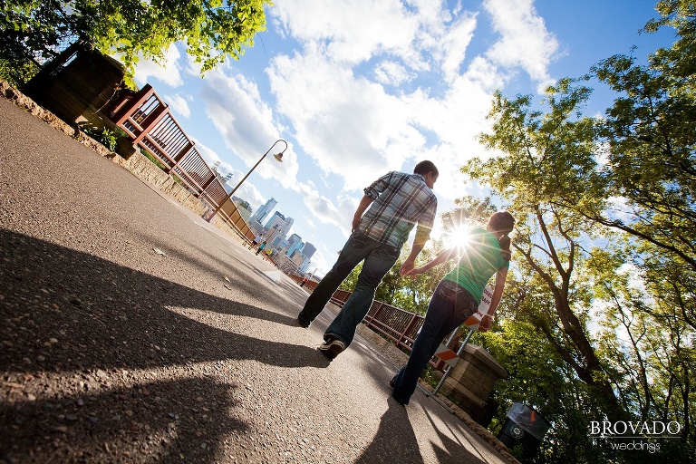 couple holding hands on stone arch bridge