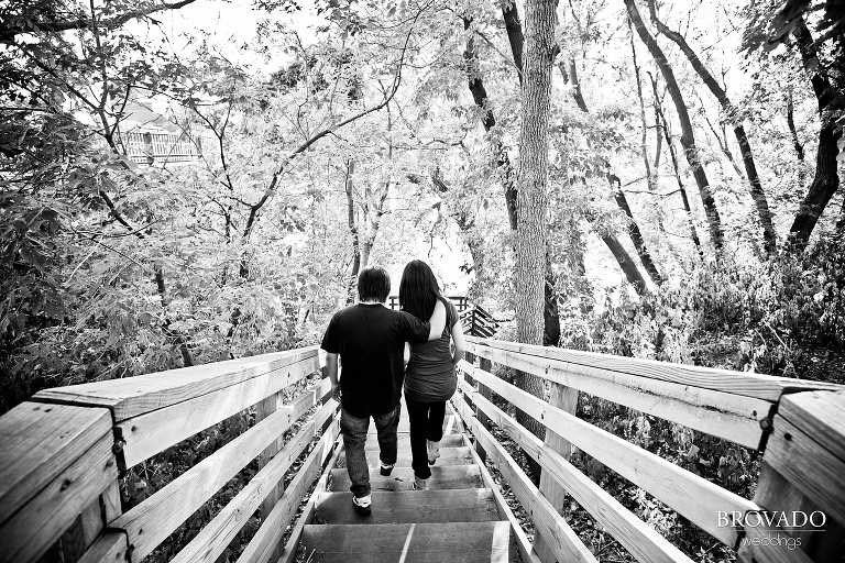 couple walking down wooden steps in black and white engagement photograph