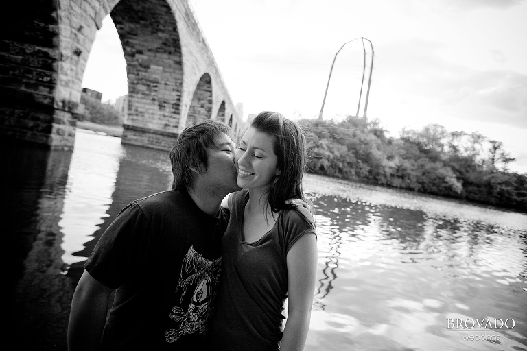 man kissing his fiance on the cheek in front of mississippi river