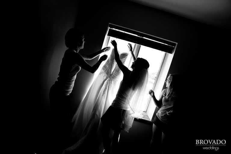 black and white photograph of bride holding up her wedding dress