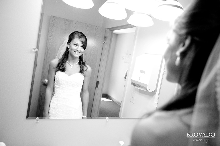 black and white photograph of bride smiling in a mirror