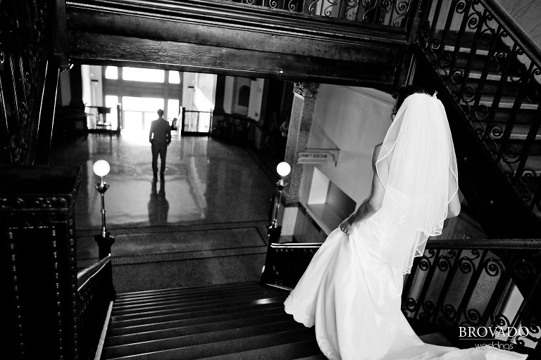 black and white image of bride sneaking up on the groom for their first look