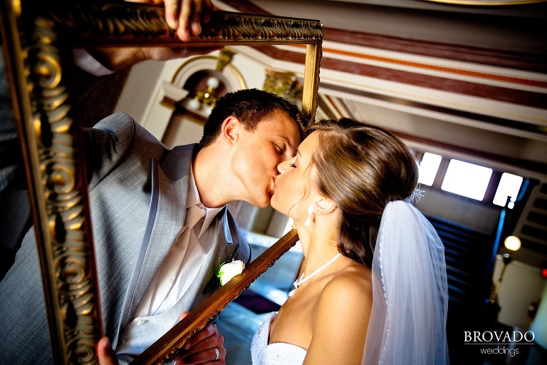 bride and groom kissing through picture frame