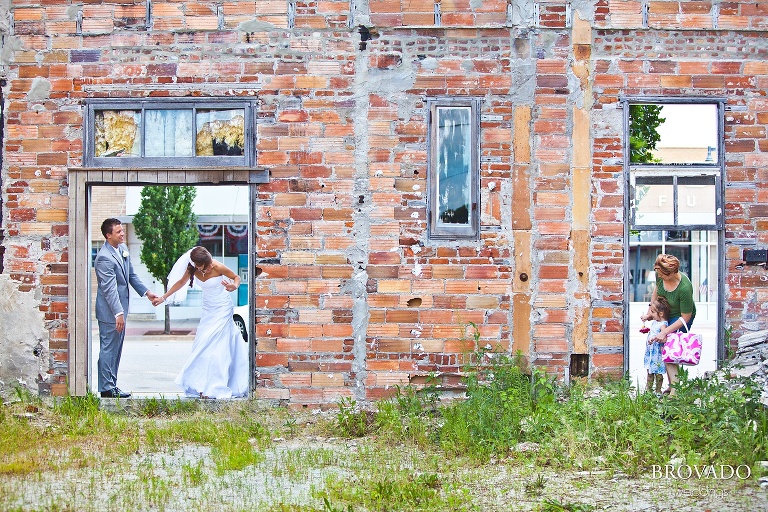 bride and groom waving at a small girl