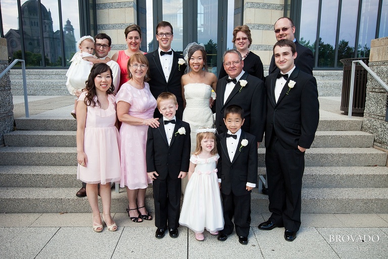 bride and groom pose with their family on minnesota historical society steps
