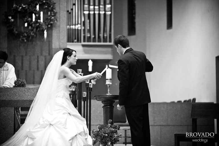bride and groom lighting unity candle during wedding ceremony