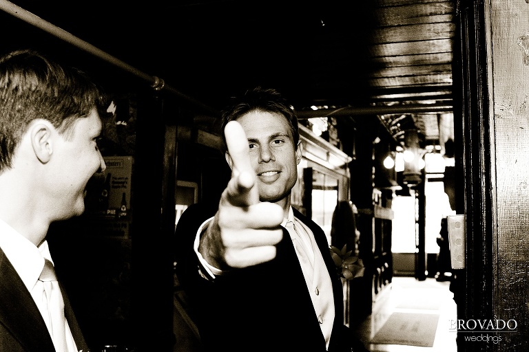 groomsman goofily pointing finger gun at the camera in sepia photograph