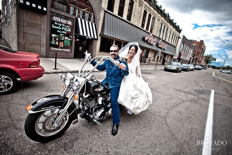 bride sitting on the back of a motorcycle in her wedding dress